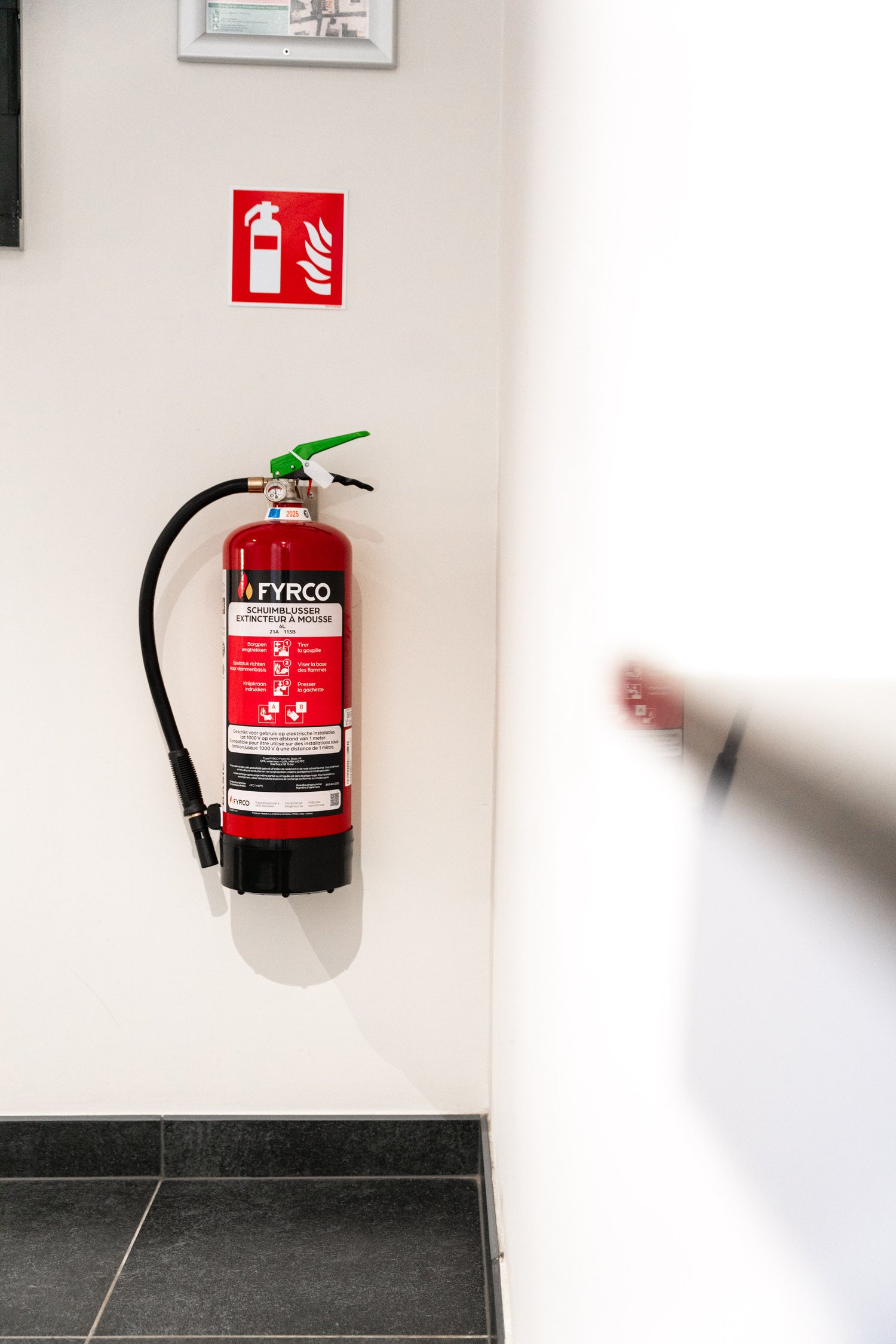 FYRCO brandblusser gemonteerd aan de muur met duidelijk brandblusserpictogram.