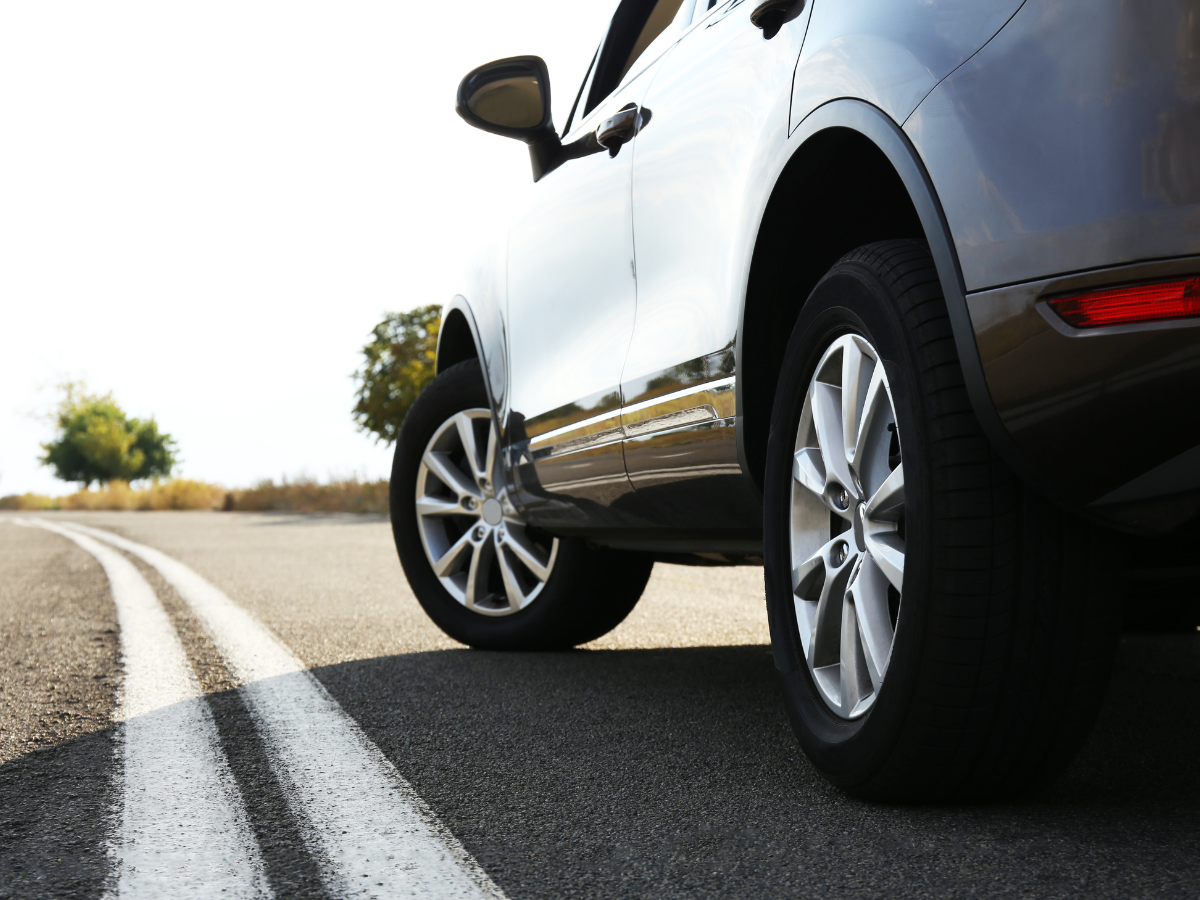 Auto geparkeerd langs de kant van de weg, gezien van dichtbij ter hoogte van de wielen