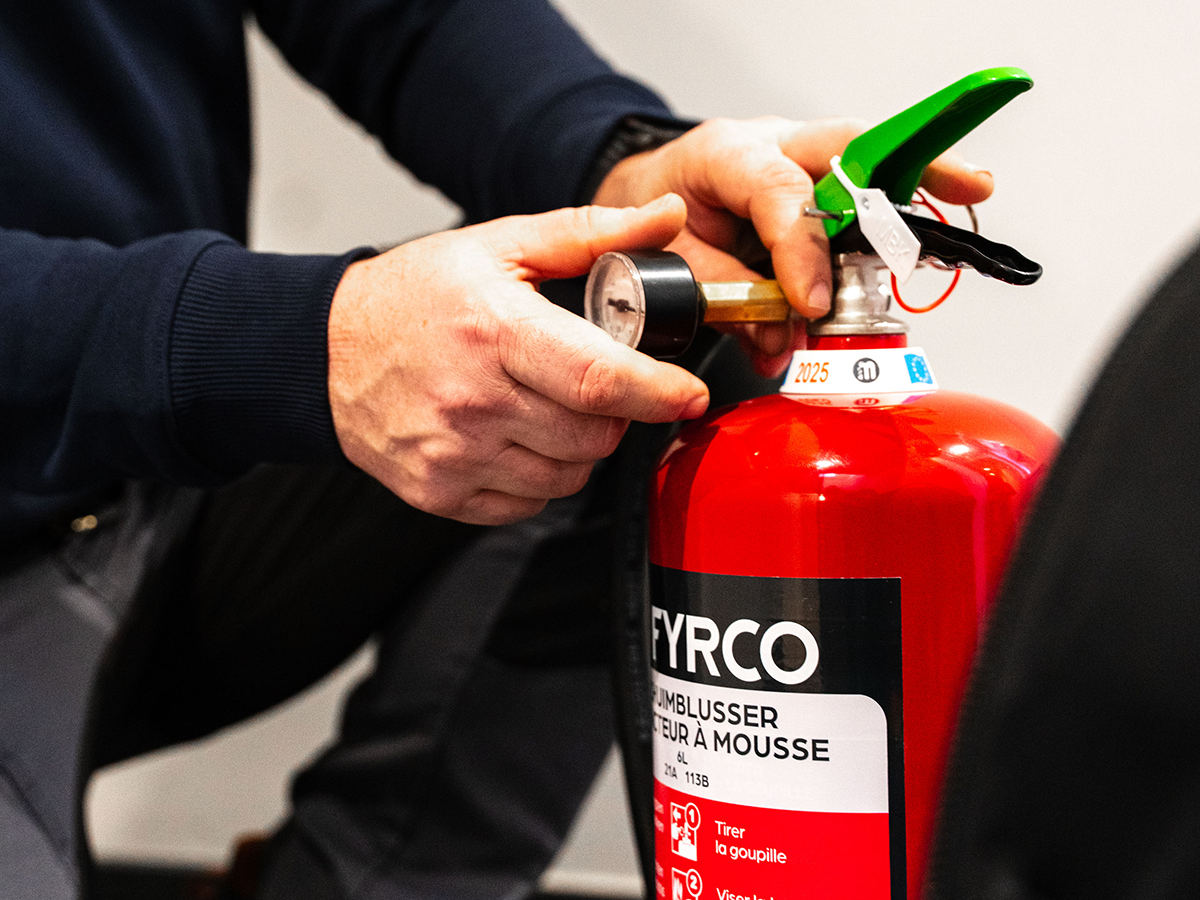 Technieker van FYRCO controleert de druk van een brandblusser tijdens periodiek onderhoud