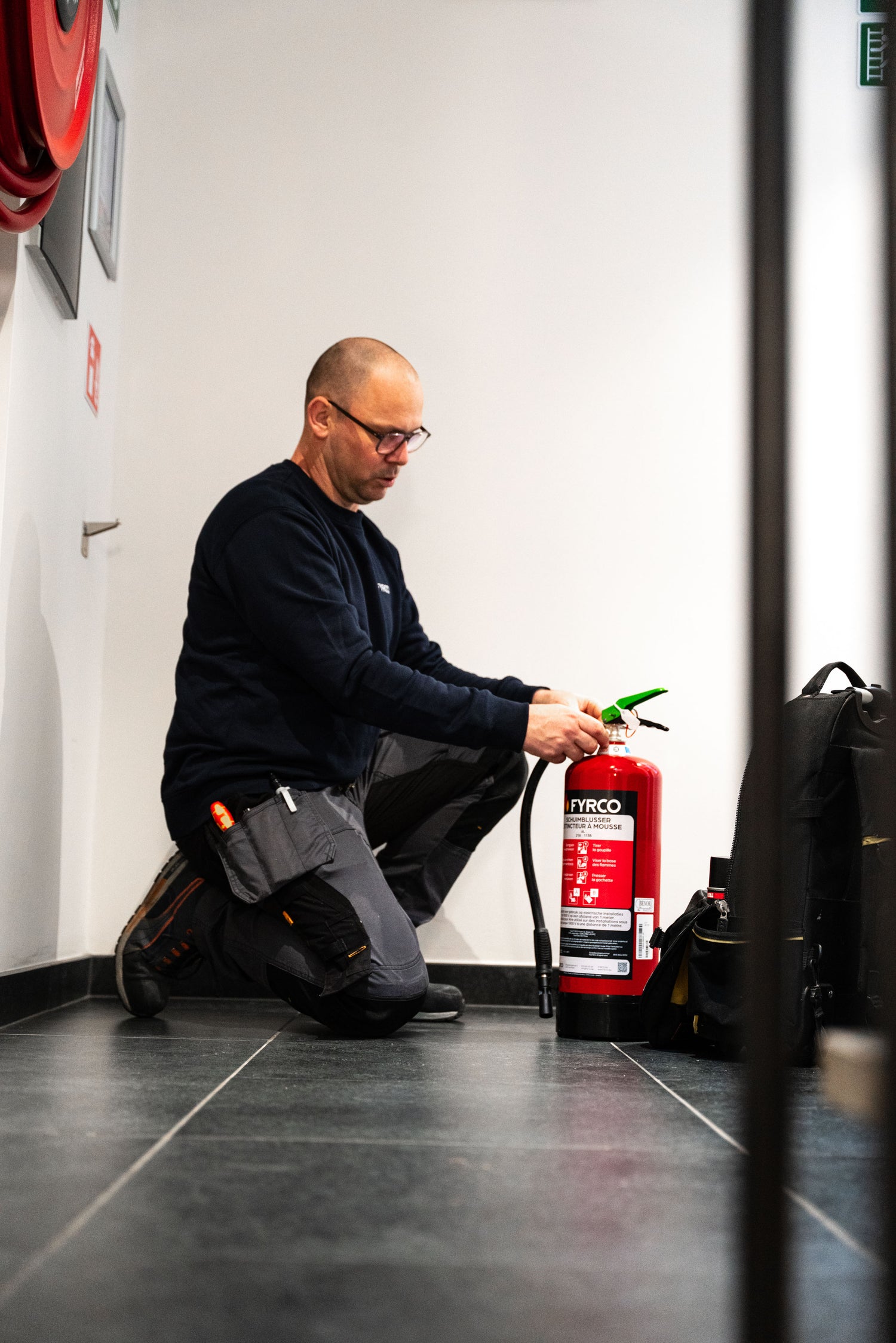 FYRCO technieker voert onderhoud uit aan een brandblusser tijdens een controle op locatie.