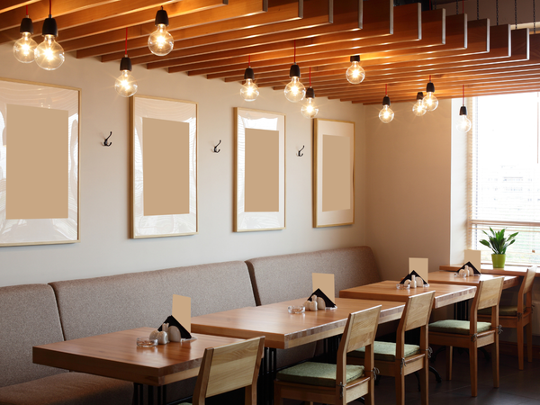 Gezellige restaurantzaal met houten tafels, zitbanken, stoelen en warme hanglampen