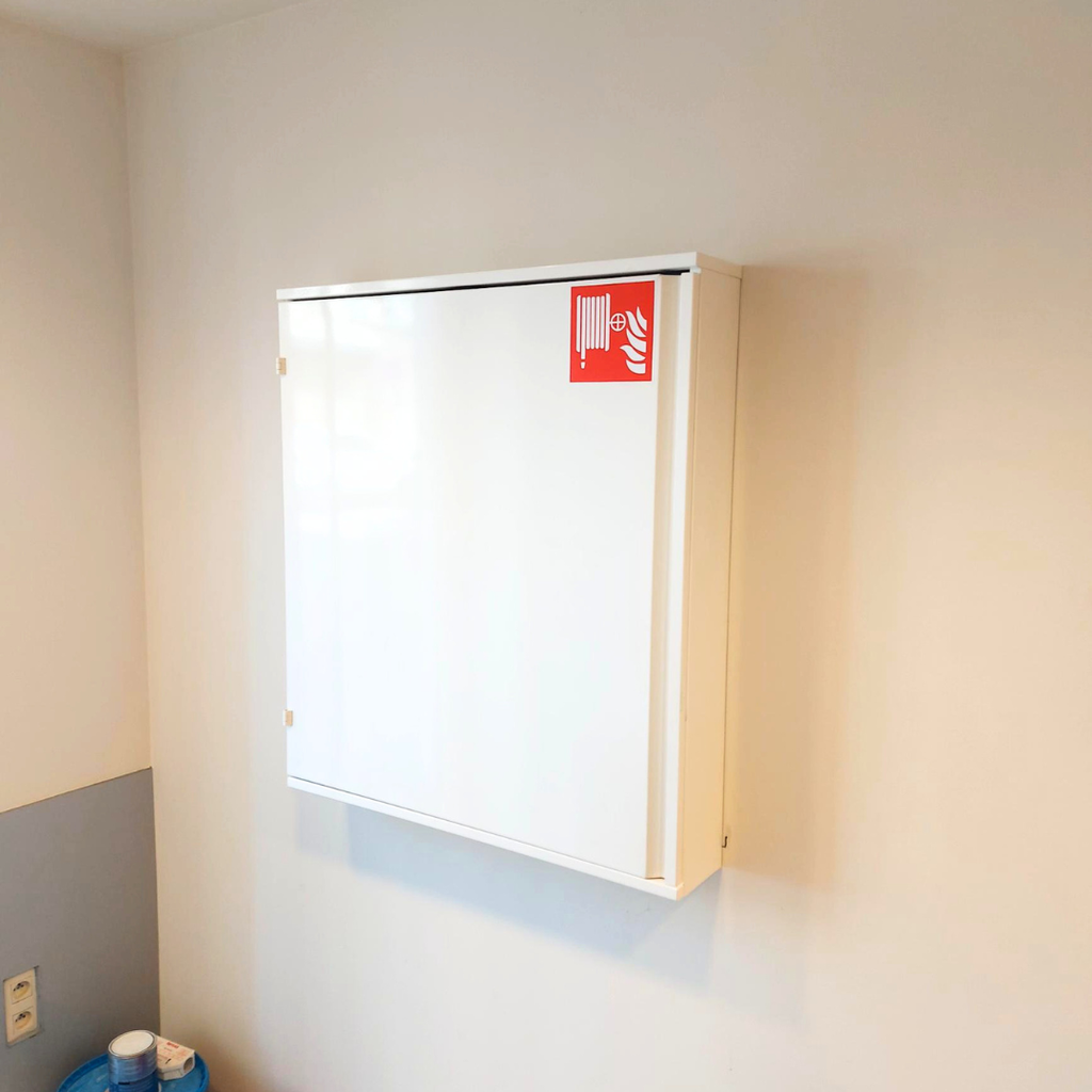 Witte brandhaspelkast met rood pictogram van een brandhaspel geïnstalleerd aan een muur